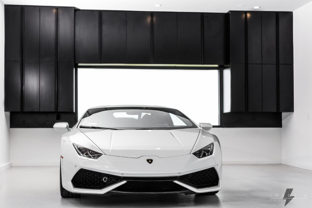 Clean, all-black cabinet layout in front of a white luxury car