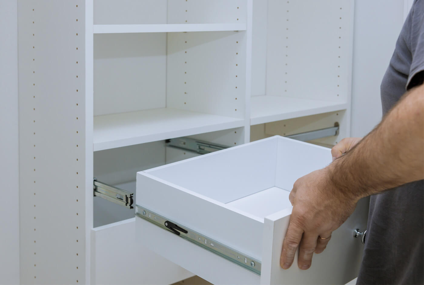 a man opening a white drawer