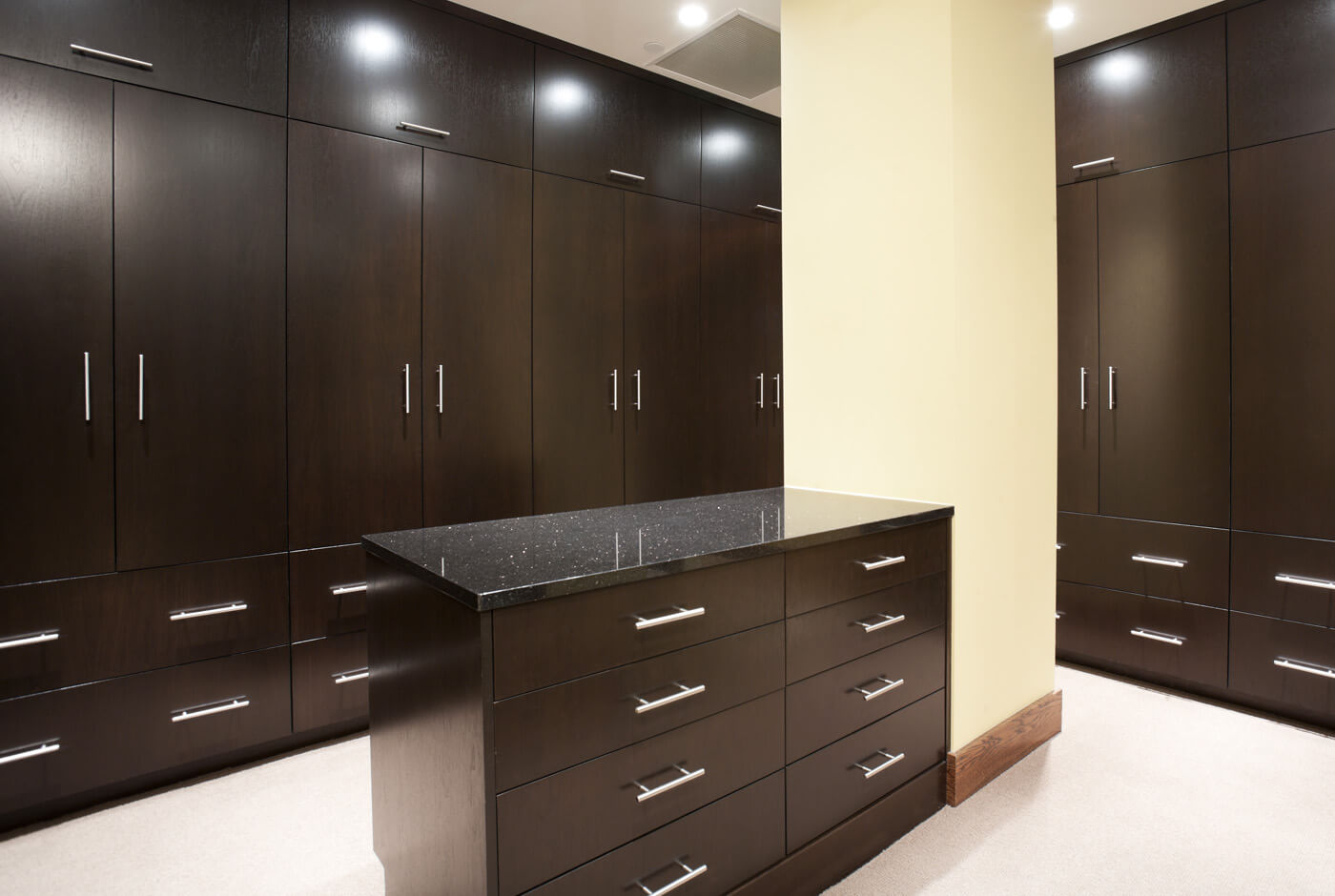 a room with dark cabinets and a counter